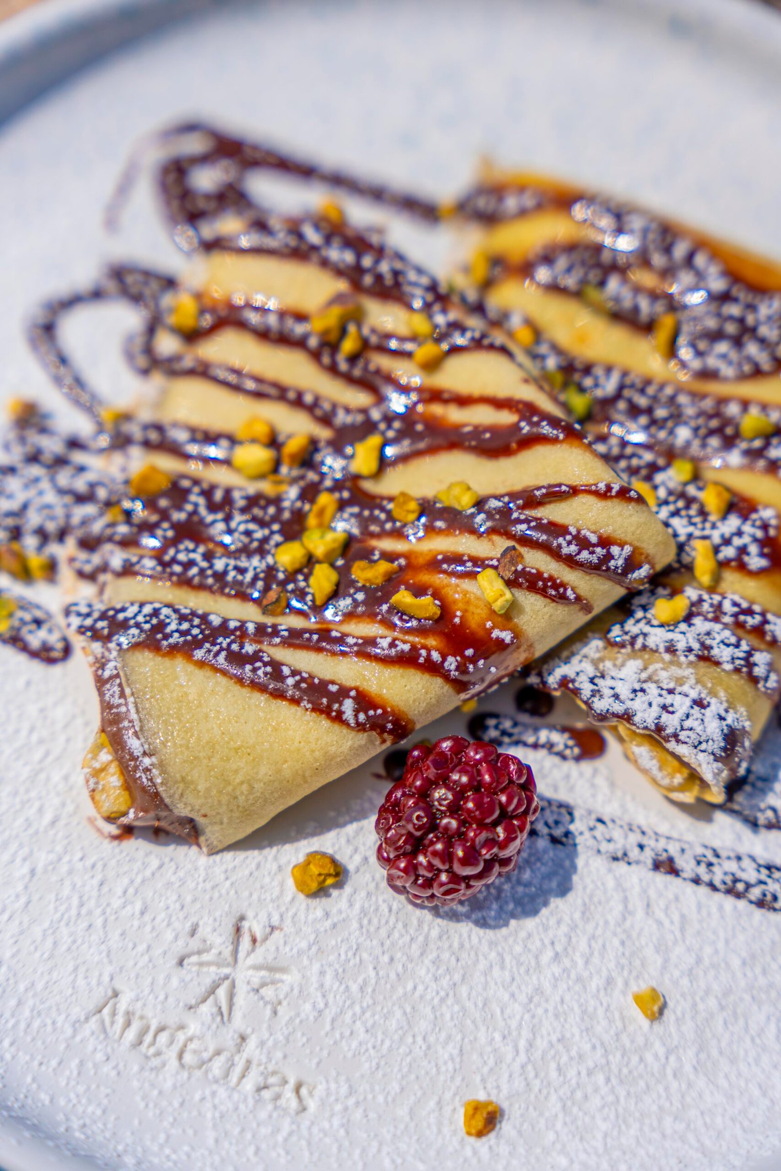 Crêpes con cioccolato, zucchero a velo e granella di pistacchio – dessert creativo del bistró Angedras ad Alghero